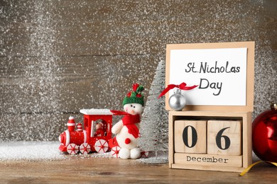 Photo of Saint Nicholas Day. Block calendar with date December 06, card and festive decor on wooden table