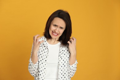 Portrait of angry woman on yellow background. Hate concept