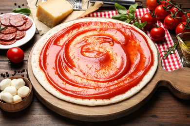 Base and fresh ingredients for pepperoni pizza on wooden table