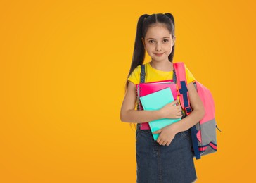 Little girl with school stationery on yellow background, space for text