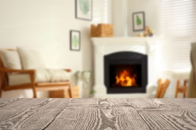 Empty wooden surface and blurred view of fireplace in room