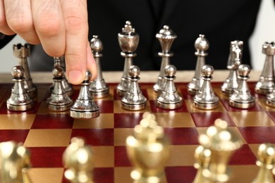 Man moving chess piece on board, closeup