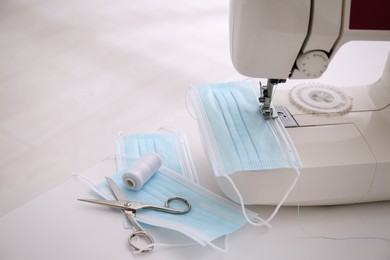 Sewing machine with disposable face mask on table, space for text