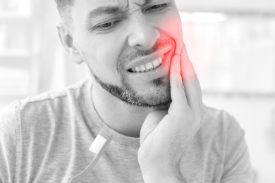 Man suffering from strong toothache at home