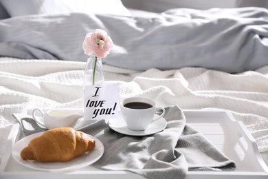 Romantic breakfast with note saying I Love You on bed