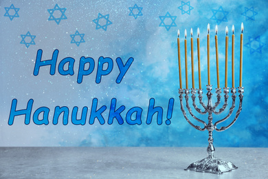 Silver menorah on grey table. Happy Hanukkah!