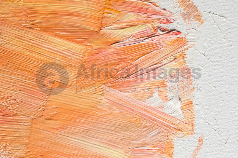 Photo of Beautiful strokes of colorful oil paints on white canvas, closeup