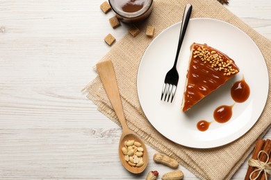 Photo of Tasty cheesecake with caramel and nuts served on white wooden table, flat lay. Space for text