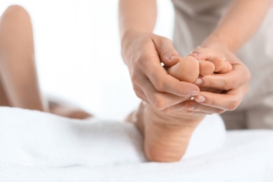 Woman receiving foot massage in wellness center, closeup