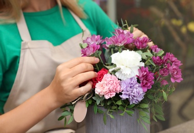 Female florist making beautiful bouquet in flower shop, closeup