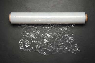 Photo of Roll of plastic stretch wrap film on black table, top view