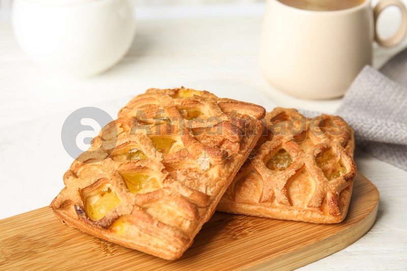 Photo of Fresh tasty pastries on white wooden table, closeup