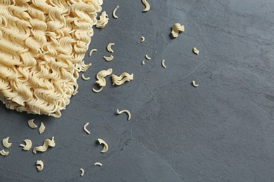 Block of quick cooking noodles on color background, top view. Space for text
