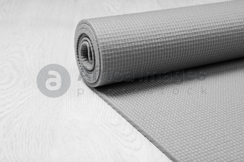 Photo of Rolled sports mat on wooden background. Space for text