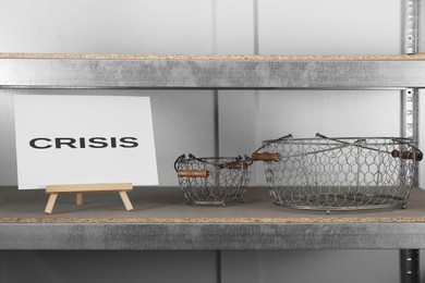 Wooden easel with word Crisis on canvas at shelf