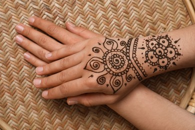 Woman with beautiful henna tattoo on hand, top view. Traditional mehndi