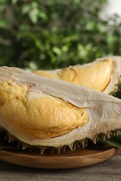 Photo of Pieces of fresh ripe durian fruit on wooden table, closeup