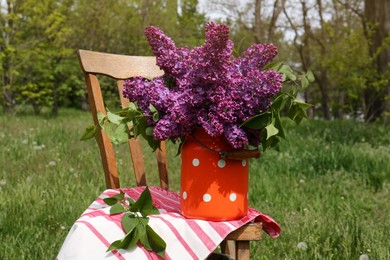 Beautiful lilac flowers in milk can outdoors