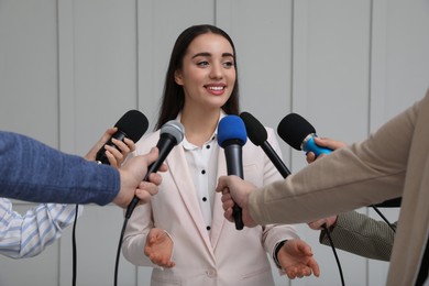 Photo of Happy business woman giving interview to journalists at official event