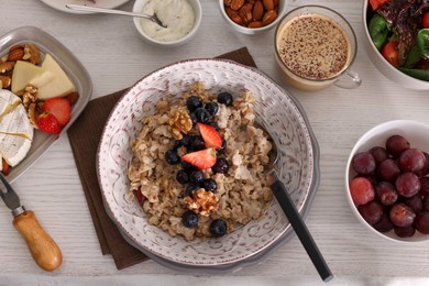 Oatmeal with fruits and nuts served on buffet table for brunch, flat lay