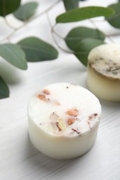 Soap bar and green leaves on white wooden table. Eco friendly personal care product