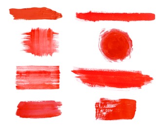 Different red paint strokes drawn with brush on white background, top view