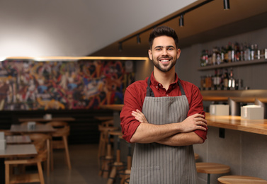 Young male business owner standing in his cafe. Space for text