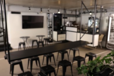 Photo of Blurred view of hostel dining room interior with comfortable furniture and coffee shop