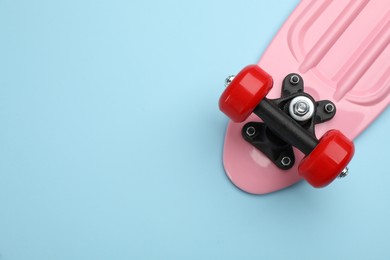Skateboard on turquoise background, top view. Space for text
