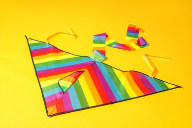 Beautiful bright rainbow kite on yellow background