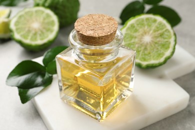 Bottle of bergamot essential oil on grey table, closeup