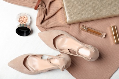 Flat lay composition with beige lady's shoes on white wooden table