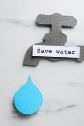 Paper tap with words Save Water and drop on white table, flat lay