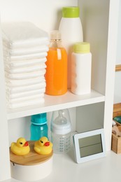 Toys and baby accessories on white rack