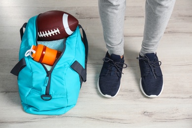 Young man in sportswear and bag with gym equipment indoors