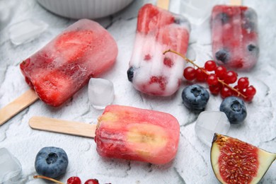 Tasty fruit and berry ice pops on light table, closeup