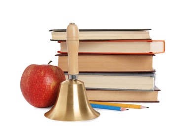 Golden school bell with wooden handle, apple and stack of books on white background