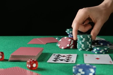 Man taking casino chips while playing poker at table, closeup. Space for text