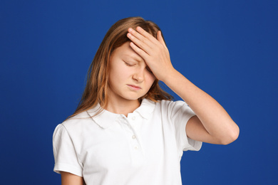 Photo of Portrait of emotional preteen girl on blue background
