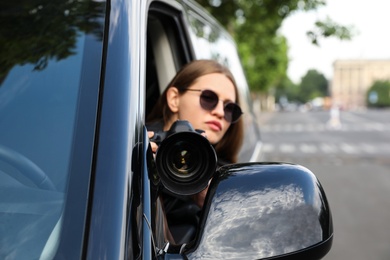 Private detective with camera spying from car, focus on lens