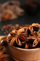 Aromatic anise stars and spices on black table, closeup