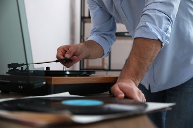 Man using turntable at home, closeup view