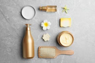 Flat lay composition with hair cosmetic products on grey marble table