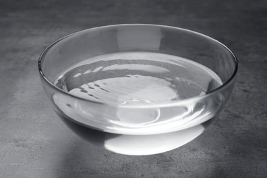 Photo of Glass bowl with water on grey table