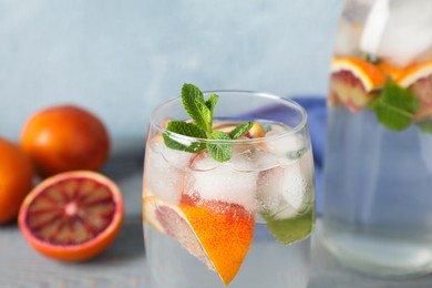 Delicious refreshing drink with sicilian orange and mint on grey table, closeup