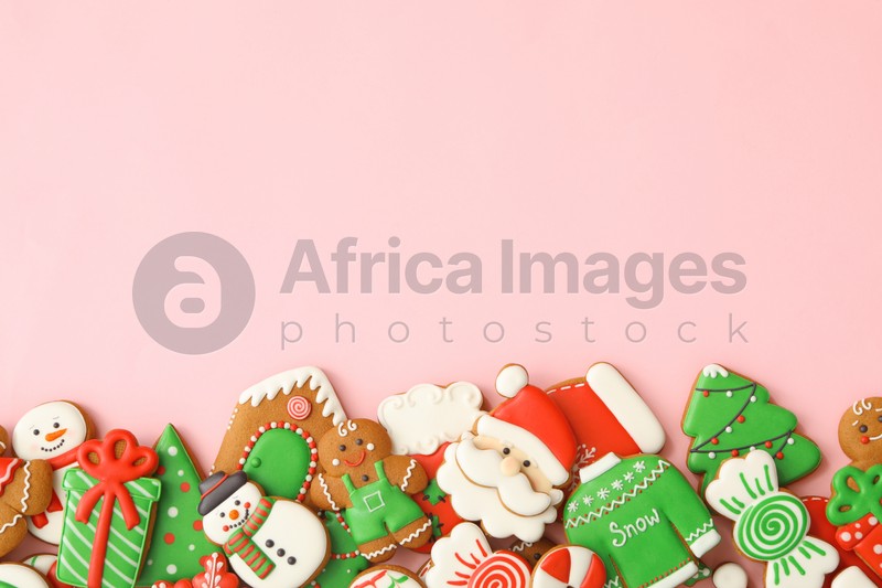 Different Christmas gingerbread cookies on pink background, flat lay. Space for text