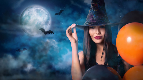Witch with balloons and full moon in misty sky on Halloween