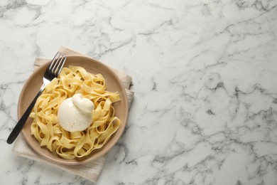 Delicious pasta with burrata cheese on white marble table, top view. Space for text