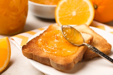 Delicious toasts with orange marmalade on table, closeup