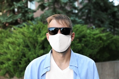 Man wearing handmade cloth mask outdoors. Personal protective equipment during COVID-19 pandemic